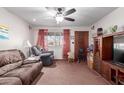 Comfortable living room with plush seating, ceiling fan and a bright window with red curtains at 306 N Winthrop Cir, Mesa, AZ 85213