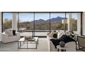Bright living room with comfortable white sofas, mountain views, and large windows at 40198 N 105Th Pl, Scottsdale, AZ 85262