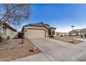 Well maintained single Gathering home with beige stucco exterior and a two car garage with desert landscaping at 41848 W Michaels Dr, Maricopa, AZ 85138