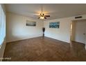 Bright living room featuring neutral walls, tile floors, ceiling fan, and natural light from a large window at 4655 W Sunnyside Ave, Glendale, AZ 85304