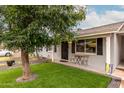 Charming single-story home featuring an easy care front yard with a small bistro table at 5016 N 68Th Dr, Glendale, AZ 85303