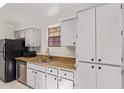 Bright kitchen featuring stainless steel dishwasher, white cabinets, and granite countertops at 8020 E Thomas Rd # 105, Scottsdale, AZ 85251