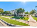 A well-maintained lawn and inviting front exterior, highlighting the charming two-story gray and white home at 10451 E Natal Ave, Mesa, AZ 85209