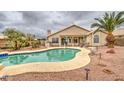 Inviting backyard featuring a refreshing swimming pool, lush landscaping, and a covered patio area at 12450 W Holly St, Avondale, AZ 85392