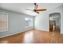 Bright, airy living room features gleaming hardwood floors, neutral paint, and a view into the kitchen at 14932 W Lamoille Dr, Surprise, AZ 85374