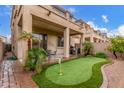 Relaxing backyard with putting green, patio, and desert landscaping perfect for outdoor entertaining at 1562 W Lacewood Pl, Phoenix, AZ 85045