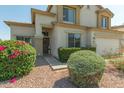 Inviting home entrance with a decorative wreath and lush, colorful landscaping at 17751 W Bloomfield Rd, Surprise, AZ 85388