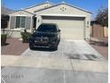 Front exterior showcasing a two-car garage and well-maintained landscaping at 18642 W Yucatan Dr, Surprise, AZ 85388