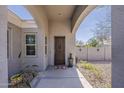 Inviting covered entryway featuring a decorative front door, manicured landscaping, and exterior lighting at 21359 E Camacho Rd, Queen Creek, AZ 85142