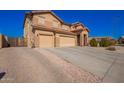 Two-story home boasts a three-car garage and desert landscaping, showcasing the property's curb appeal at 224 N 236Th Ave, Buckeye, AZ 85396