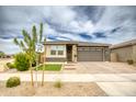 Lovely single-story home with a manicured front lawn, stylish front door, and a two-car garage at 22474 E Lawndale E Pl, Queen Creek, AZ 85142