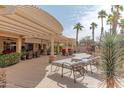 Spacious backyard with a covered patio, lush greenery, mature palm trees and stylish outdoor furniture at 2612 N 161St Ave, Goodyear, AZ 85395