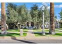 Charming home with a well-manicured lawn, mature trees, a classic streetlight, and a welcoming walkway leading to the front door at 348 W Portland St, Phoenix, AZ 85003