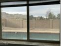 Window view overlooks backyard pool, desert landscaping, and a mountain in the background at 4416 E Capistrano Ave, Phoenix, AZ 85044