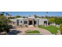 Stunning Santa Fe-style home with beautiful stone accents, desert landscaping, and circular driveway at 4438 E Millbrae Ln, Gilbert, AZ 85234