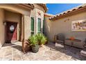 Cozy front porch with tiled flooring, patio furniture, potted plants, and a decorative star at 4444 W Chama Dr, Glendale, AZ 85310