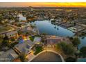 Panoramic aerial view of a lakeside community with beautiful homes, sparkling pools, and manicured lawns at twilight at 479 E Horseshoe Pl, Chandler, AZ 85249