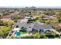 An aerial view of the home's backyard and a large outdoor seating area, pool and a lush green lawn at 6114 E Calle Del Norte --, Scottsdale, AZ 85251