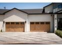 Two-car garage features custom doors, decorative lighting, and a modern driveway at 6114 E Calle Del Norte --, Scottsdale, AZ 85251