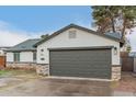 Single-story home showcasing a gray two-car garage, modern lighting, and stylish stone detailing at 6812 S 41St Pl, Phoenix, AZ 85042