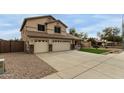 Two-story home featuring a three-car garage, desert landscaping, and green lawn at 9627 W Reno View Dr, Peoria, AZ 85345