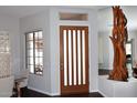 Elegant entryway featuring a wood door with glass inserts, adjacent to the formal dining area, and wood flooring at 10960 N 78 St, Scottsdale, AZ 85260