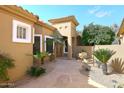 Inviting home featuring a beautiful stone courtyard, mature trees and plants, and desert landscaping at 10960 N 78 St, Scottsdale, AZ 85260