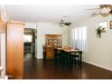 Bright dining space with hardwood floors, a stylish ceiling fan, and a classic wooden hutch with glass doors at 13216 S 175 Dr, Goodyear, AZ 85338