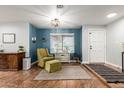 Comfortable living room with a chair, ottoman, and shelving next to a window with view of the front yard at 14042 N 44Th St, Phoenix, AZ 85032