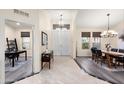 Bright foyer leads to living spaces, showcasing tile and wood flooring with neutral walls at 16253 W Windcrest Dr, Surprise, AZ 85374