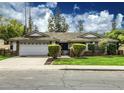 Charming home with well-maintained lawn, stylish stone accents, and a two-car garage at 2053 W Natal Cir, Mesa, AZ 85202