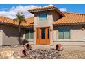 Inviting front entrance showcases unique landscaping and a striking orange door, offering a warm welcome at 2585 Leisure World --, Mesa, AZ 85206