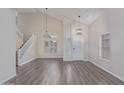 Bright living room with high ceilings, modern lighting, and new laminate floors at 25872 W Hilton Ave, Buckeye, AZ 85326