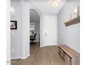 Inviting entryway with light gray walls, decorative shelf, wood-look flooring, and a bench at 3541 E Amber Ln, Gilbert, AZ 85296