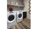 Well-lit laundry room with a modern washer and dryer, shelving, and stylish decor at 3892 W Antelope Way, San Tan Valley, AZ 85144