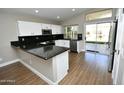 Modern kitchen features white cabinetry, black granite countertops, and stainless steel appliances and wood floors at 4002 E Rockwood Dr, Phoenix, AZ 85050