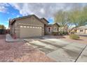 Single-story home featuring a two-car garage with a long driveway and desert landscaping at 46175 W Morning View Ln, Maricopa, AZ 85139