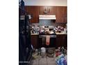 Untidy kitchen space showing cabinets, appliances, and tiled floor at 510 N Bass Rd, Wickenburg, AZ 85390