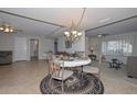 Open dining room area filled with natural light, featuring a round table and ornate chandelier at 5223 W Acoma Dr, Glendale, AZ 85306