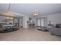 Spacious living room featuring tile floors, ceiling fan, and a seamless transition to the dining area at 5223 W Acoma Dr, Glendale, AZ 85306