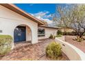 Attractive front entrance with arched entryway, brick pavers, and a blue double door at 6036 E Windsor Ave, Scottsdale, AZ 85257