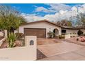 Inviting single-story home features a brick-lined driveway and a two-car garage at 6036 E Windsor Ave, Scottsdale, AZ 85257