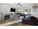 Bright living room with a fireplace, large windows, and wood flooring at 686 E Vermont Dr, Gilbert, AZ 85295