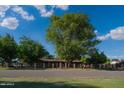 Inviting single-story home with a secure fenced yard, mature landscaping, and picturesque street view at 7216 W Country Gables Dr, Peoria, AZ 85381