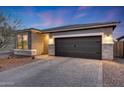 Single-story home featuring stone accents, a paver driveway, and a two-car garage nestled within a well-kept lawn at 738 W Kingman Dr, Casa Grande, AZ 85122