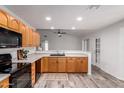 Well-lit kitchen featuring wooden cabinets, sleek black appliances, and seamless open floorplan at 8027 E Quarterline Rd, Mesa, AZ 85207