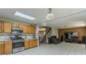 Kitchen with stainless steel appliances, wood cabinets, and an open layout leading to the living area at 8163 E Posada Ave, Mesa, AZ 85212
