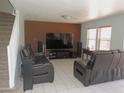 Living room with tile floors, modern leather sofas, television and speakers at 8163 E Posada Ave, Mesa, AZ 85212