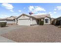 Charming single-story home with a two-car garage, desert landscaping, and American flag displayed at 8226 W Eugie Ave, Peoria, AZ 85381