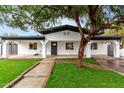 Inviting home with a classic white facade, black trim, and a mature shade tree at 833 S Toltec --, Mesa, AZ 85204